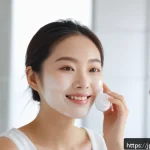 다기능 BB크림과 CC크림 비교 - A close-up portrait of a young Japanese woman applying creamy BB cream to her face in a bright, mode...